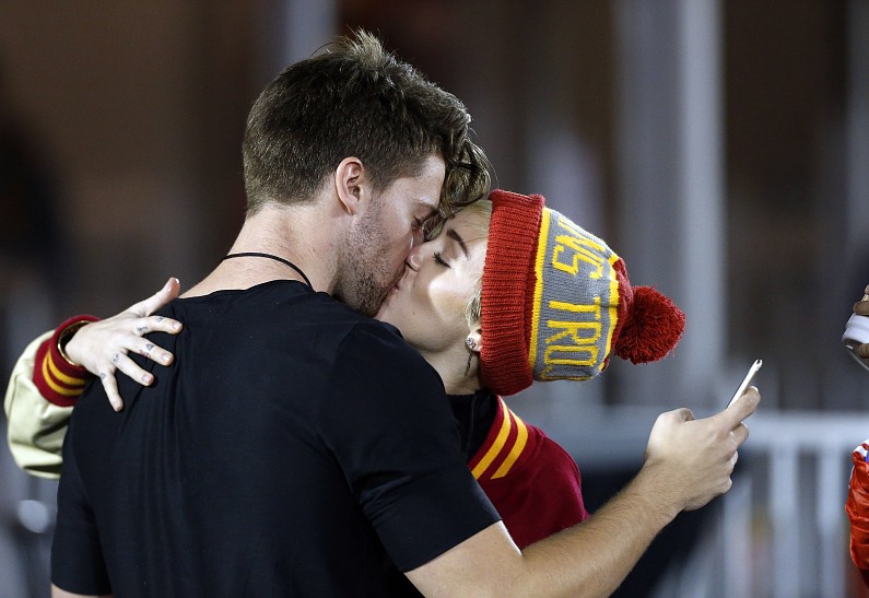 Майли Сайрус и Патрик Шварценеггер целуются на футбольном матче